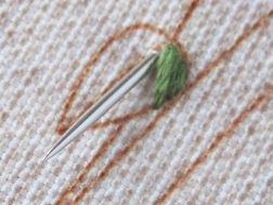 Фото процесса вышивки нитками гладьевым швом зеленого листочка